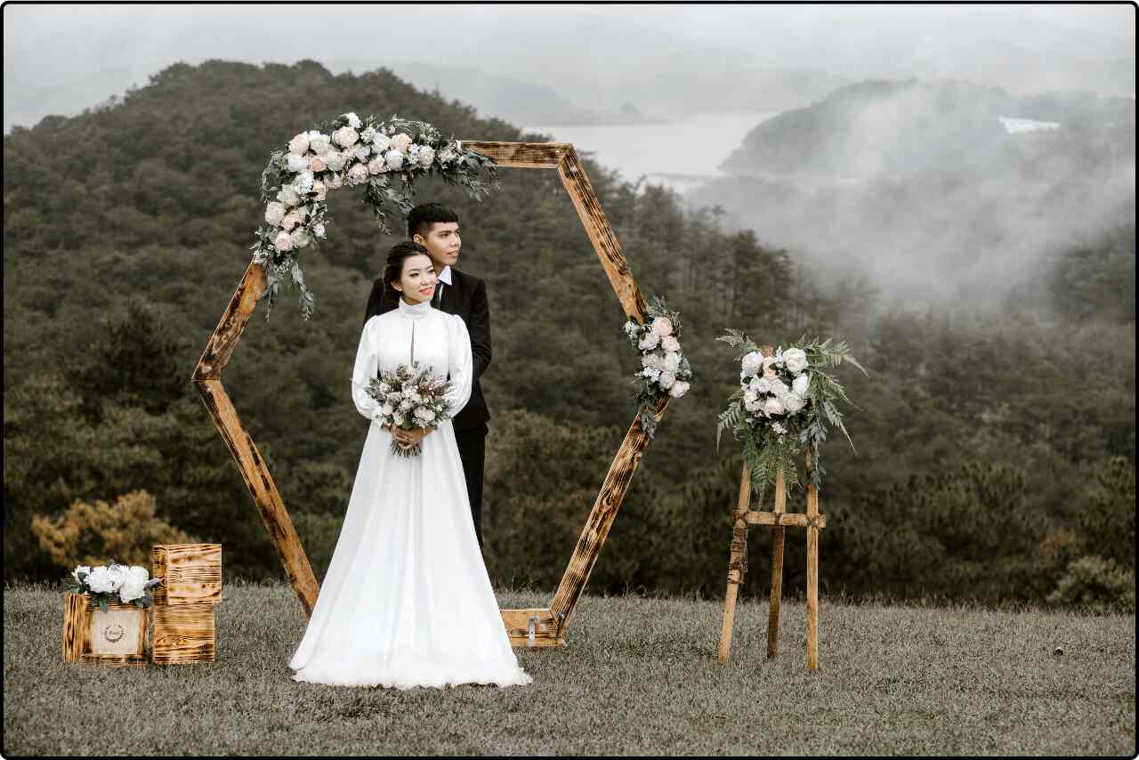 The bride and groom standing on a scenic overlook with mountains in the background, capturing a perfect blend of nature and romance.